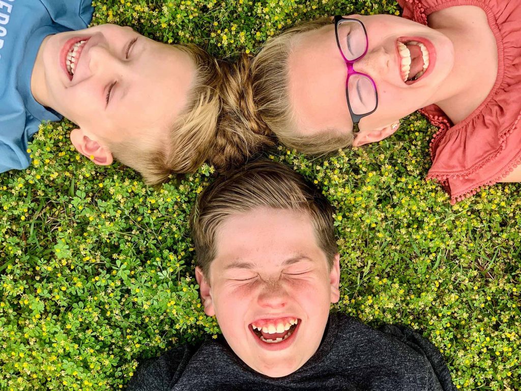 Group of kids laying on the ground smiling