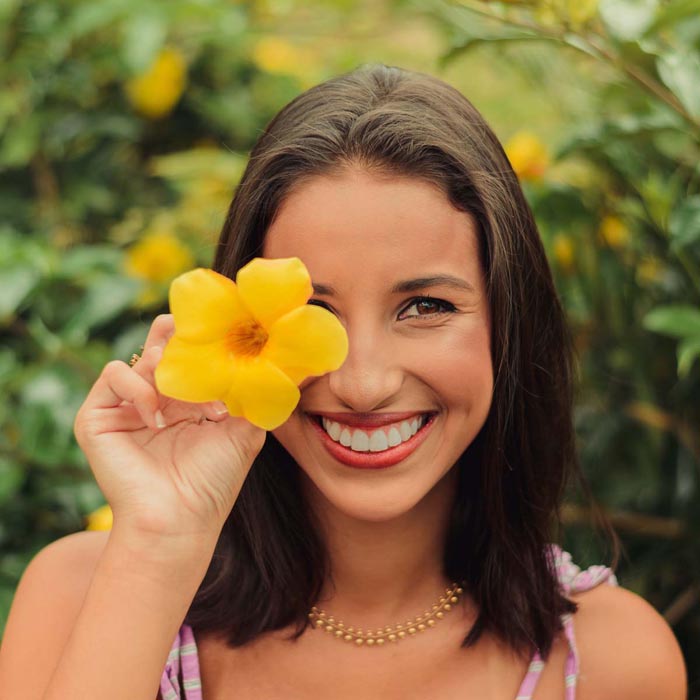 Woman smiling with a yellow flower